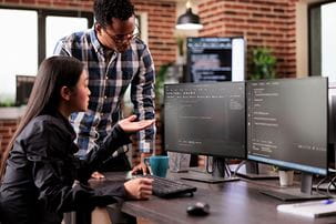 Asian American woman being helped with computer issue by African American man